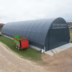 Duża hala namiotowa na wsi, obok przyczepa rolnicza. Czy na hale namiotową potrzebne jest pozwolenie?