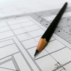 Ołówek na planach budowlanych. Podwykonawca przygotowuje zgłoszenie podwykonawcy do inwestora.