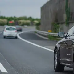 Czarny SUV na autostradzie, obok białe samochody. Kiedy można wyprzedzać z prawej strony? Gdy lewy pas jest wolny, a prawy służy do wyprzedzania.