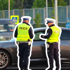 Policjanci kontrolują kierowcę, który prawdopodobnie otrzyma mandat za jazdę z hakiem.