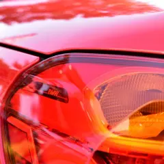 Czerwone BMW, błyszczące w słońcu, symbolizuje dynamiczna jazda co to znaczy – moc i precyzję na drodze.
