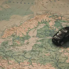 Czarny model samochodu na mapie Europy, sugerujący podróż 1000 km samochodem.