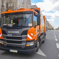 Pomarańczowy śmieciarka Scania na ulicy w Warszawie. Zakaz wjazdu tirów w centrum miasta nie dotyczy pojazdów komunalnych.
