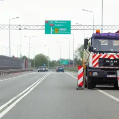 Ciężarówka drogowa z pachołkami ostrzegawczymi. Kierowca może otrzymać mandat za wyprzedzanie na podwójnej ciągłej.