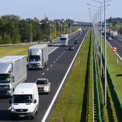 Ciężarówki i samochody osobowe na drodze dwupasmowej. Wyprzedzanie na drodze dwupasmowej jest w pełni widoczne.