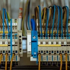 Zasilanie placu budowy z przyłącza docelowego. Widać tu szczegół instalacji elektrycznej z wieloma przewodami w różnych kolorach podłączonymi do listew zaciskowych.