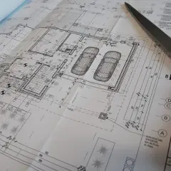 Projekt architektoniczno budowlany i projekt techniczny domu z garażem, z widocznymi elementami technicznymi i nożyczkami.