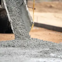 Beton wylewany z gruszki na budowie. Czy droga jest obiektem budowlanym? Powstaje nowa nawierzchnia.