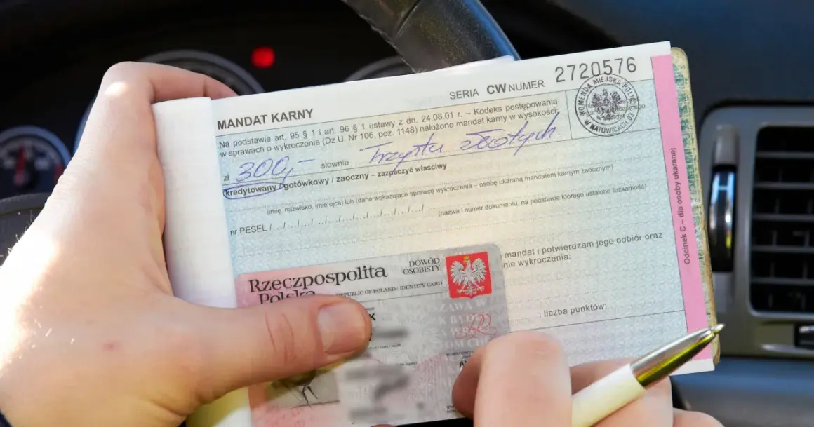 Ręce trzymają mandat karny na 300 zł. Wpisano "trzysta złotych", ale nie widać, ile punktów ma młody kierowca.