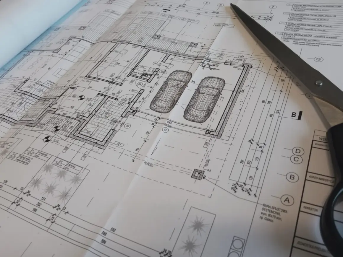 Projekt architektoniczno budowlany i projekt techniczny domu z garażem, z widocznymi elementami technicznymi i nożyczkami.
