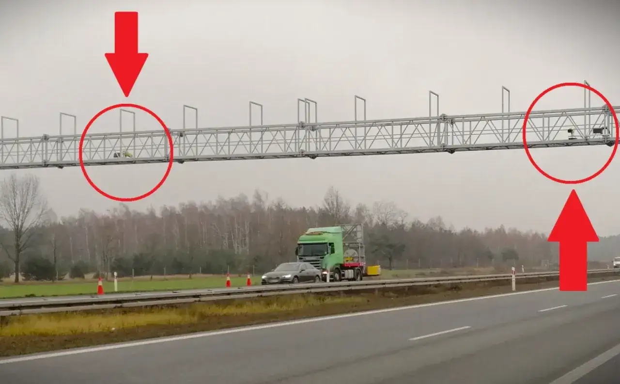 Na autostradzie A2 widać system odcinkowy pomiar prędkości. Czerwone strzałki wskazują kamery rejestrujące pojazdy.