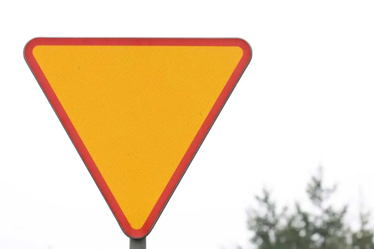 Żółty trójkąt z czerwoną obwódką, znak ustąp pierwszeństwa. Zbliża się droga podporządkowana, czas na ostrożność.